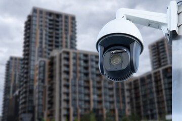 Panoramic view of CCTV surveillance camera with blurred apartment building background with copy...