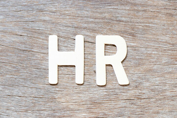 Alphabet letter in word HR (Abbreviation of human resource) on wood background