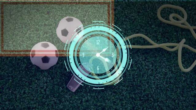 Animation of neon ticking clock over close up of miniature soccer balls and whistle on grass field