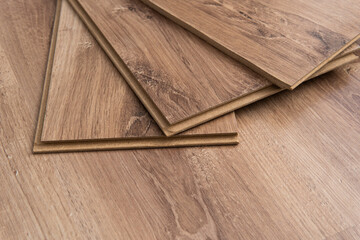 Fototapeta premium Installing laminated floor, detail on wooden tiles ready to be fit.