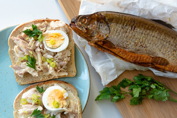 Sandwich with smoked trout and egg for breakfast