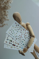 sliders for nails.manicure stickers.close-up stickers.close-up sliders.wooden man.wooden man holding sliders