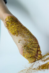 foot in gold.leg of a girl in sequins.foot close-up.sequins on the leg.naked sequins.women's shin