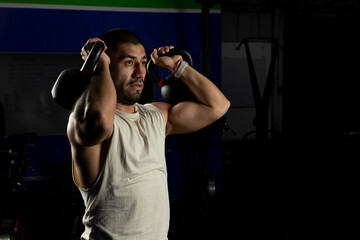 close up of man with 2 kettlebells doing arm exercises