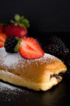 Macro Image of Chocolate Pastry with Strawberries, Blackberries and Powdered Sugar on Black Background