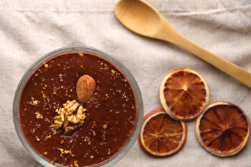 Bowl of homemade chocolate chia pudding, made with dark chocolate, chia seeds, orange juice and plant based milk. Top view.