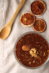 Bowl of homemade chocolate chia pudding, made with dark chocolate, chia seeds, orange juice and plant based milk. Top view.
