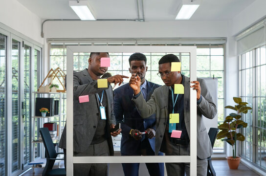 business people meeting and brainstorming discuss strategy by sticky note on transparent glass board, selective focus - Powered by Adobe
