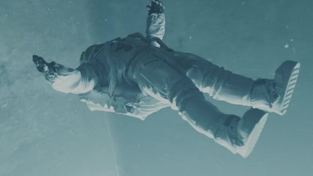 Astronaut falling down a bright path or a tunnel. Sci-fi animation. Spaceship interior. Freefall. Slow motion.