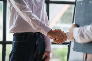 Shaking hands between business man and woman start up team in boardroom.