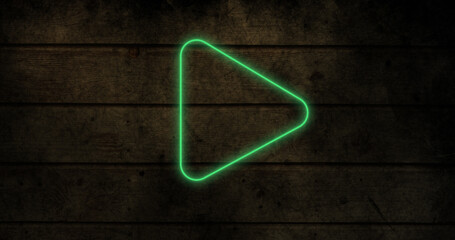 Composite of illuminated play button icon over wooden wall, copy space