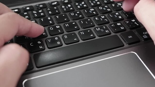 man's fingers typing keyboard black at laptop