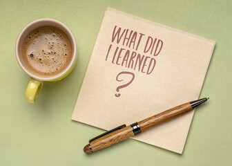 What did I learned? Handwriting on a napkin with a cup of coffee. Learning, experience and education concept.