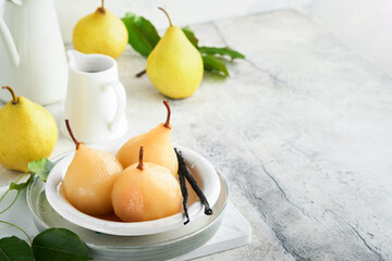 Pears. Poached pears in syrup. Traditional dessert sliced server in a white plate with leaves and at home on a light background. Delicious dessert for holiday.