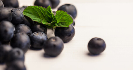 Close-up of blueberries and leaves over white background, copy space