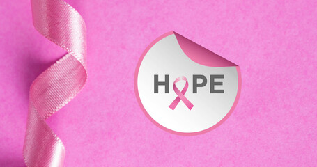 Composite of hope text in peeling circular sticker with pink awareness ribbon, copy space