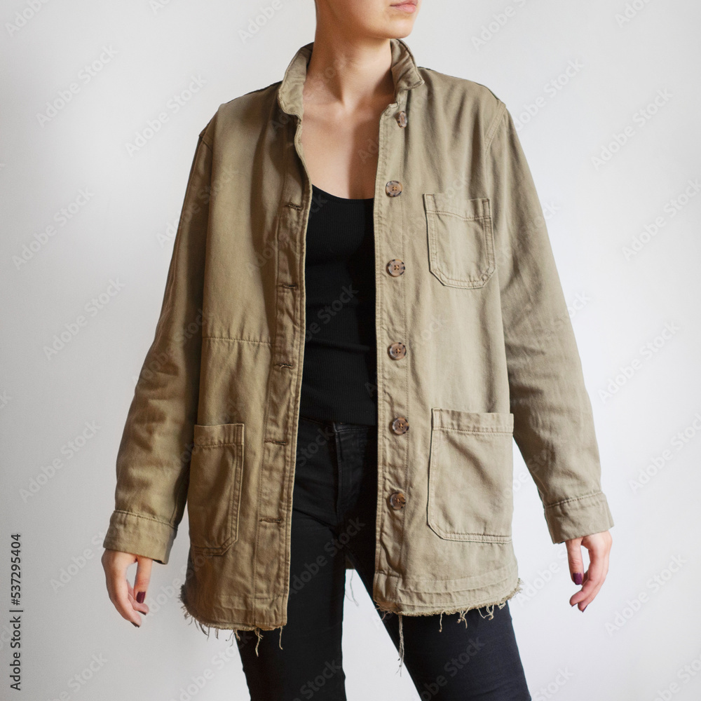 Poster woman wearing khaki jacket and black jeans isolated on white background