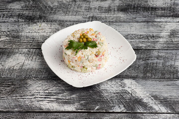 Salad, olivier salad on a wooden white background