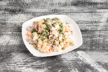 Salad, olivier salad on a wooden white background