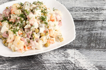 Salad, olivier salad on a wooden white background
