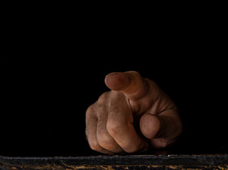 man hand reaching out from a dark place.
a worker's hand pointing to the light