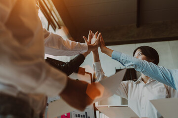 High five, teamwork concept, Asian business adviser meeting in boardroom with accounting paper charts accountancy document at desk workspace.