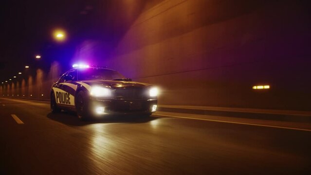 Traffic Patrol Car In Pursuit, Driving Fast with Sirens Blazing through the City Tunnel. Officers of the Law Chasing a Suspect. Cops in Squad Car React to Emergency Call. Cinematic Night Shot
