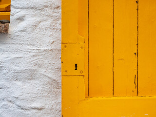 Puerta de madera amarilla en un muro blanco