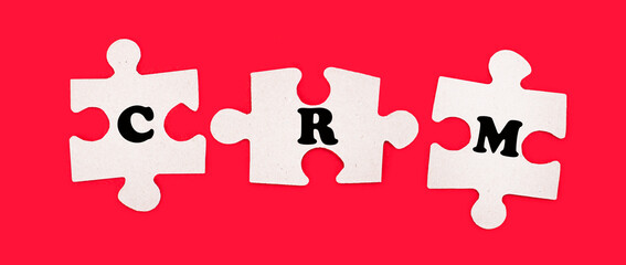 Three white jigsaw puzzles with the text CRM Customer Relationship on a bright red background.