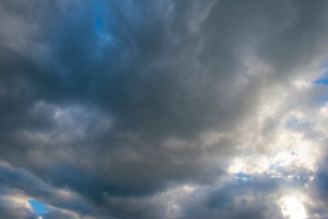 Clouds in a blue dark cloudy sky in bright sunlight in autumn at sunset, Voeren, Limburg, Belgium, October, 2022