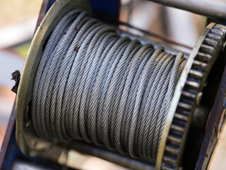 A close-up of a metal winch coil with steel cable wire on it