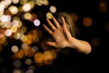 Fototapeta premium Girl hand and Christmas decoration with bokeh lights.