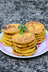closeup the bunch yellow brown bengal gram fried food with green mint in the plate soft focus natural grey brown background.