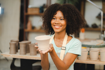 happy smiling girl having fun to learning and work with craft art of clay hand-made workshop in...