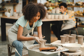 happy smiling girl having fun to learning and work with craft art of clay hand-made workshop in ceramic studio, little ceramist enjoy in creative handcraft hobby with pottery artisan school class