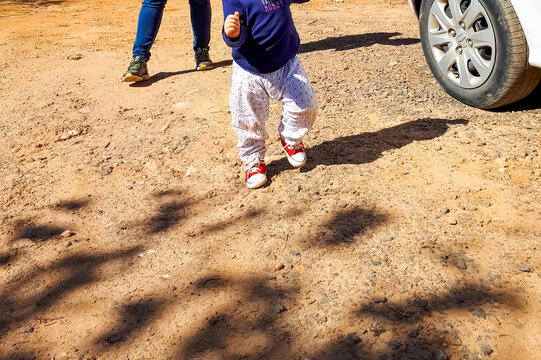 baby steps- cute baby walking on red sneakers.