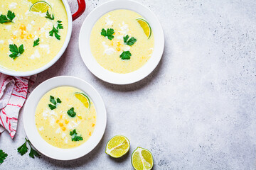 Flat lay of Mexican corn soup with cheese and herbs.