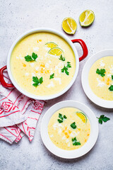 Flat lay of Mexican corn soup with cheese and herbs.