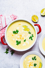 Flat lay of Mexican corn soup with cheese and herbs.