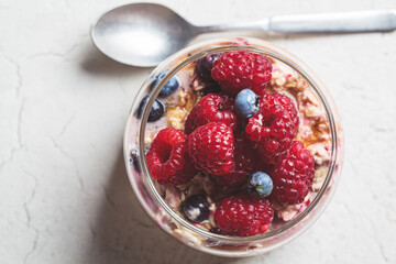 Overnight oatmeal with berry, peanut butter and maple syrup in jar. Healthy breakfast concept.