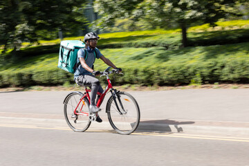 Courier On Bike Delivering Takeaway Food In City