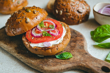 Rye bread rusted sandwich with cream cheese, fresh tomato, onion and basil. Healthy snack.