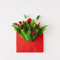 Christmas minimal concept. Creative layout made of fir branches and red paper envelope on white...