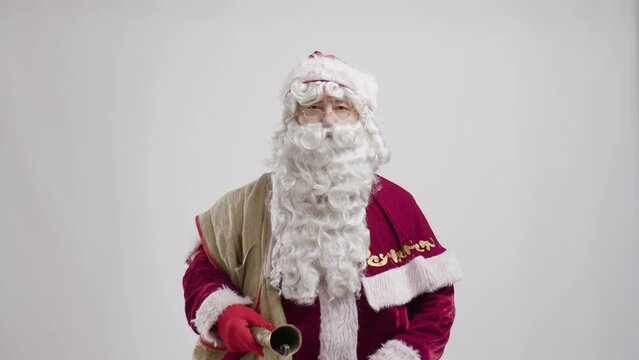 santa claus with bag and ring bell portrait standing against white background.