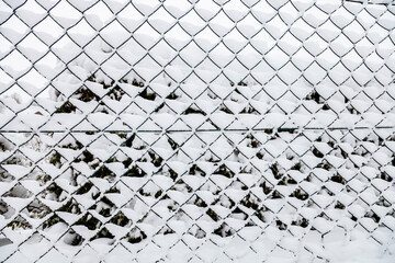 Chain link fence with snow background in wintertime - Powered by Adobe