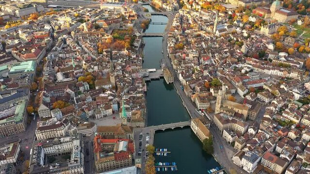 Zurich, Switzerland: Aerial footage of Zurich old town along the Limmat river with the medieval cathedral with Autumn leaf color in the Swiss largest city in fall