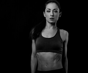 Obraz na płótnie Canvas Happy pretty fit healthy fitness woman in sporty top clothing bra looking sexy on black background with empty copy space. Healthy portrait