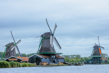 Three Dutch Windmills on the River Bank