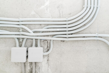 Electrical wiring in a protective corrugation on the wall. The wires and junction box are installed...