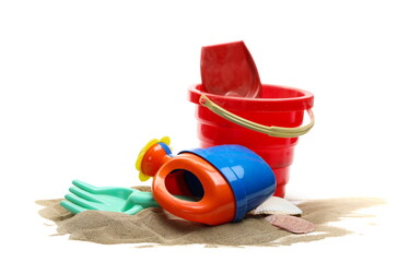 Beach toys for kids, plastic tools in sand pile isolated on white  